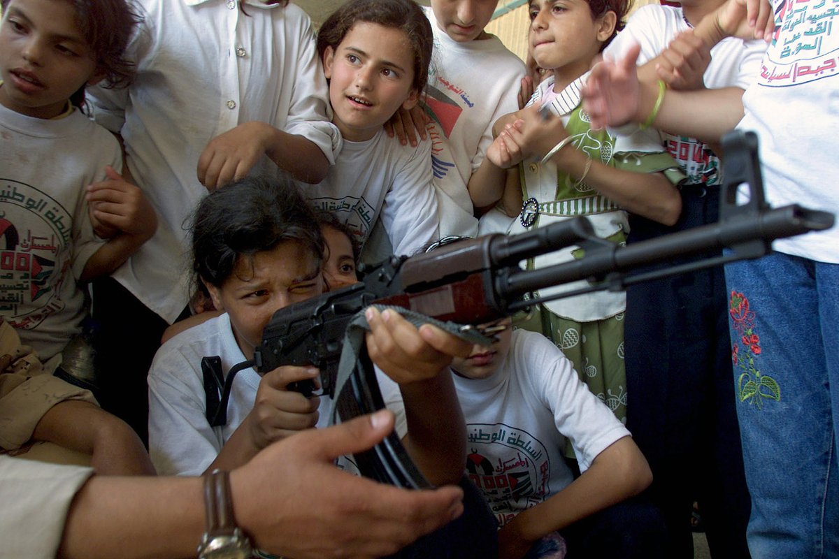 Палестинские девушки учатся пользоваться автоматом АК-47 в лагере беженцев на юге сектора Газа, 2000-е годы