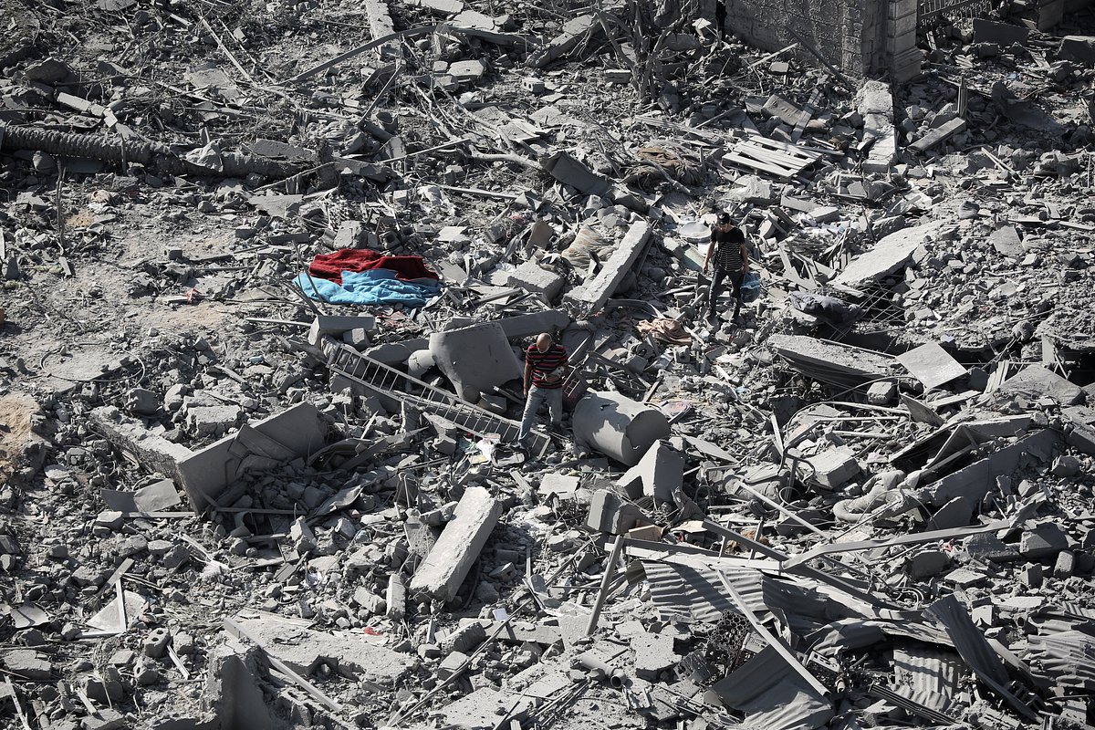 Палестинцы осматривают разрушенные после израильских авиаударов дома, сектор Газа, 13 октября 2023 года 