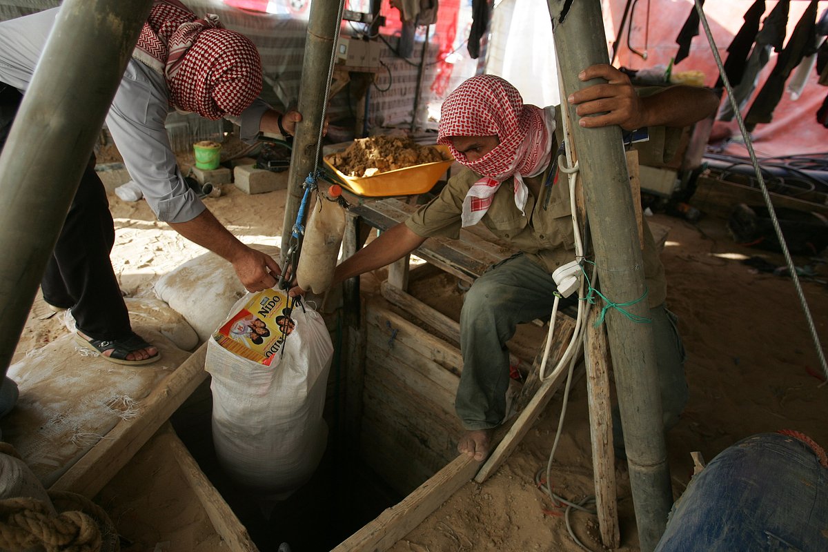 Палестинцы вытаскивают из туннеля мешки с едой, молоком и боеприпасами, которые были доставлены под землей из Египта как контрабанда, сектор Газа, Рафах, 27 июня 2008 года