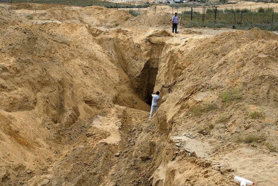 Палестинцы осматривают разрушенный туннель, соединяющий сектор Газа и Израиль, в районе Рафаха на юге сектора Газа во время 72-часового перемирия в августе 2014 года