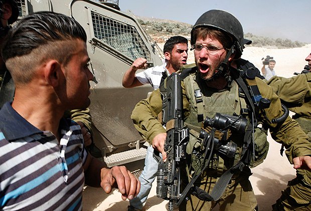 Израильский солдат конфликтует с палестинцем во время столкновений в деревне Ориф недалеко от города Наблус (Западный берег реки Иордан). 26 мая 2012 года