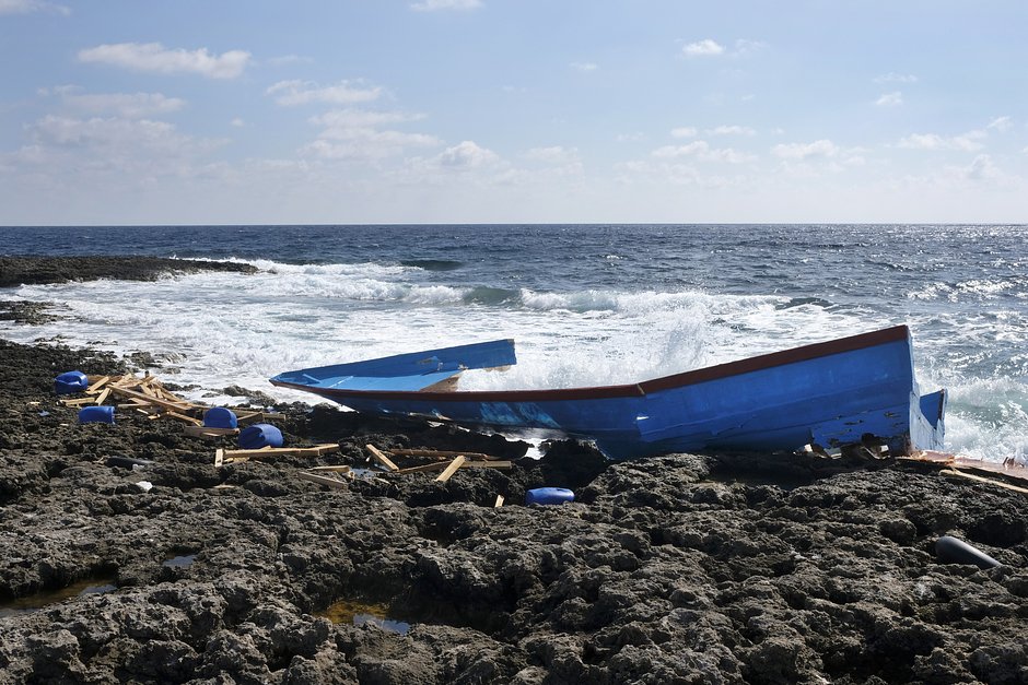Разбитая лодка нелегальных мигрантов на берегу в Пунта-Соттиле на острове Лампедуза, Италия, 21 октября 2019 года
