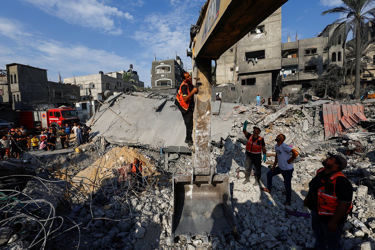 Сотрудники экстренных служб сектора Газа работают на месте израильских ударов по жилым домам