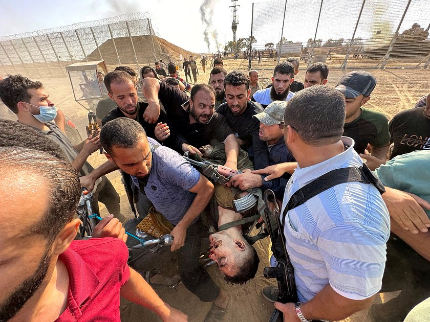 Палестинцы несут тело израильтянина, убитого ХАМАС