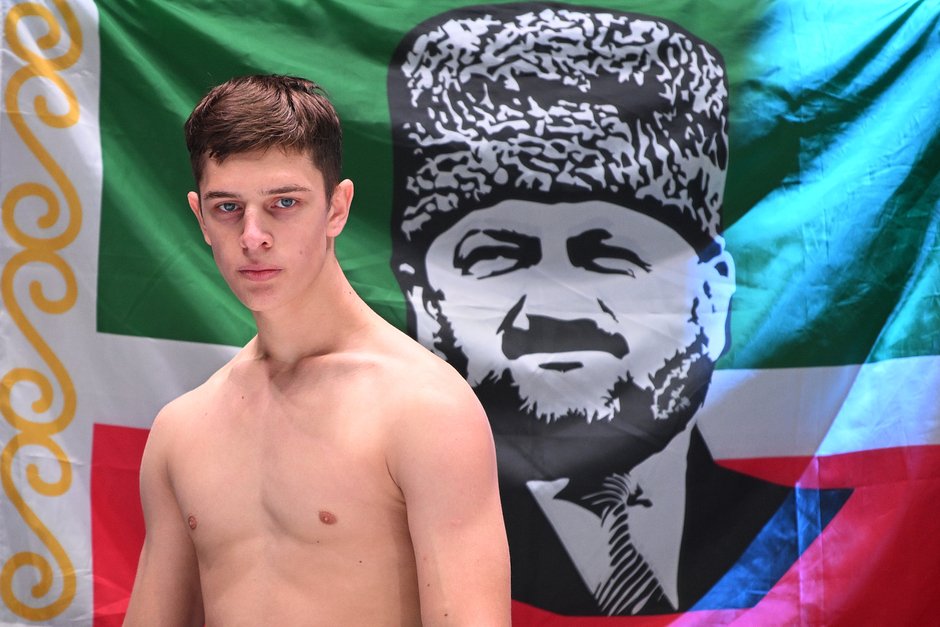 Эли Кадыров на фоне флага с портретом Ахмата Кадырова перед поединком против Ислама Акбарова на турнире по смешанным единоборствам АСА 150