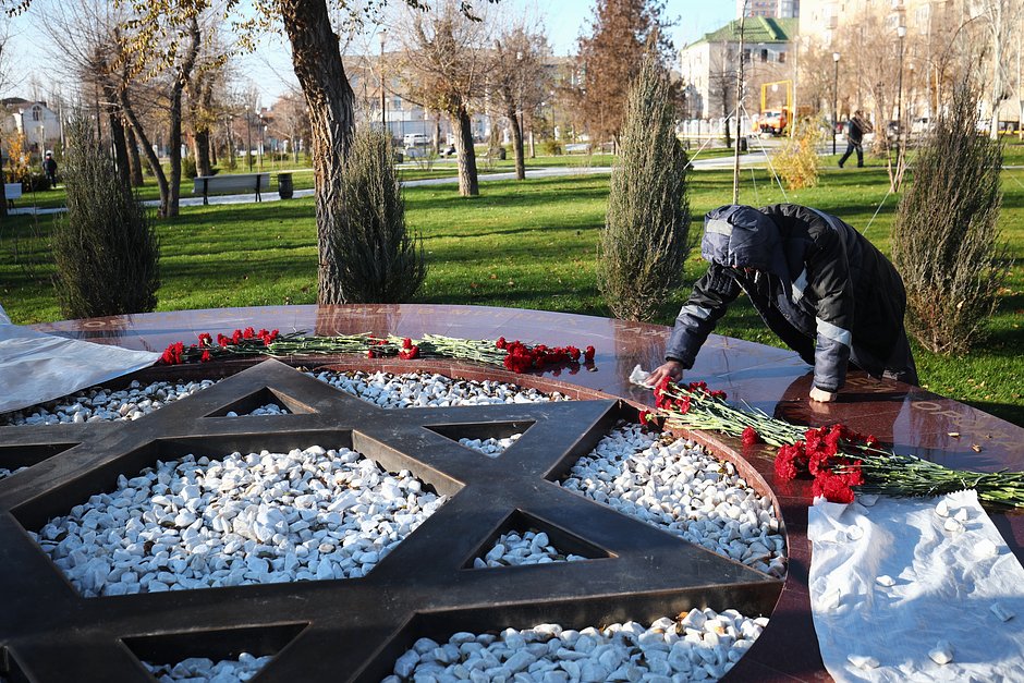 Сотрудник коммунальных служб очищает памятник евреям, который неизвестный осквернил черной краской. Волгоград, 11 ноября 2021 года