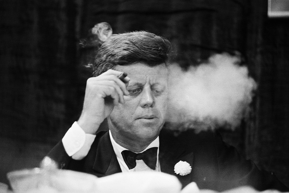 Президент Кеннеди курит сигару во время благотворительного ужина Демократической партии в Оружейной палате Содружества Бостонского университета