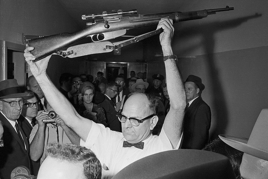 Полицейский показывает публике винтовку, из которой застрелили Кеннеди 