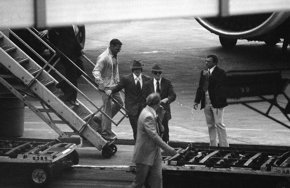 Lt. Viktor Ivanovich Belenko, Soviet pilot who defected by landing his super-secret fighter plane in Japan, leaves a commercial airline in Los Angeles on Sept. 9, 1976 with security agents. He is one of the two men dressed nearly alike at center, but officials did not say which one. The two men left the airport in a caravan of police cars.