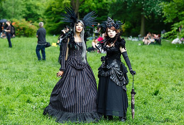 Девушки в черной одежде и шляпах с перьями позируют во время традиционного пикника в первый день ежегодного фестиваля Wave-Gotik Treffen, 2013 год
