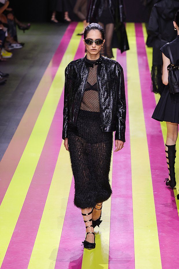 Модель в сетчатом топе и с черными полосами на губах на показе Christian Dior, 2023 год