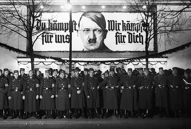Один из многих предвыборных плакатов, стоящих вдоль дороги. Надпись гласит: «Фюрер, вы сражаетесь за нас. Мы боремся за тебя»