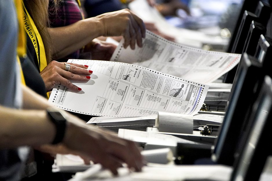 Сотрудники избирательной комиссии на складе избирательного отдела округа Аллегейни в Питтсбурге обрабатывают бюллетени с праймериз в Пенсильвании, 1 июня 2022 года