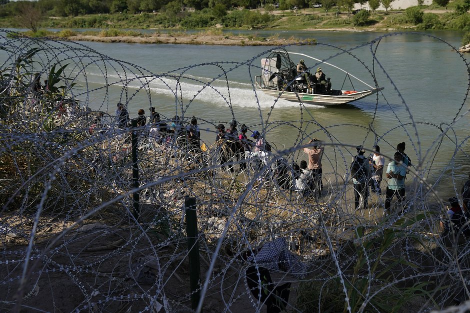 Мигрантов, пересекших границу США из Мексики, встречают пограничники на реке Рио-Гранде. Игл-Пасс, штат Техас, 21 сентября 2023 года