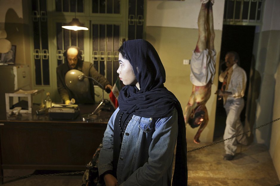 Жительница Ирана осматривает в бывшей тюрьме САВАК, ныне музее, восковые манекены следователей и заключенных, Тегеран, 7 января 2019 года