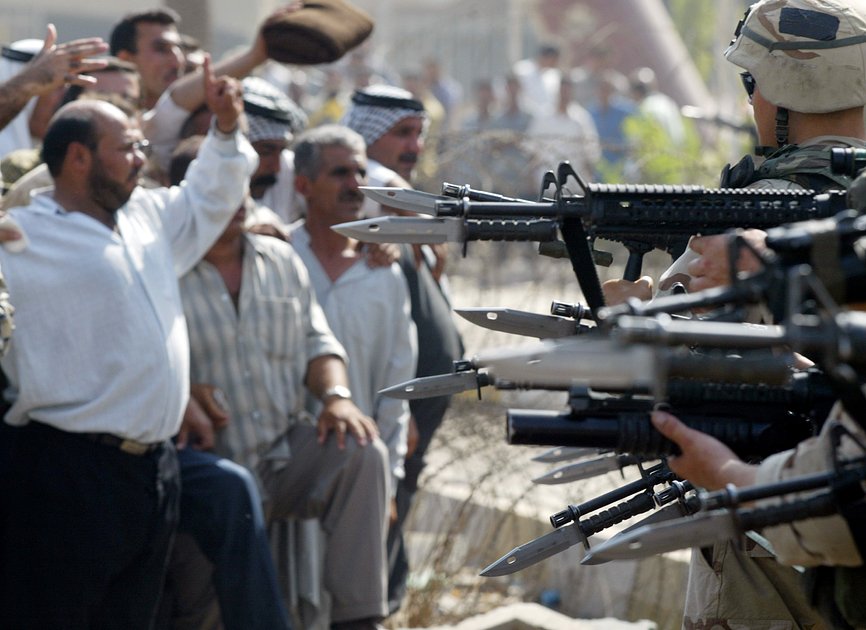 Солдаты армии США направляют винтовки на солдат иракской армии, 18 июня 2003 года