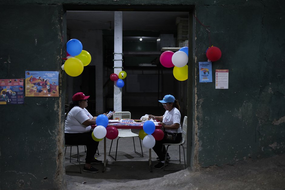Сторонники властей Венесуэлы сортируют агитационные материалы о регионе Эссекибо возле избирательного участка в Каракасе