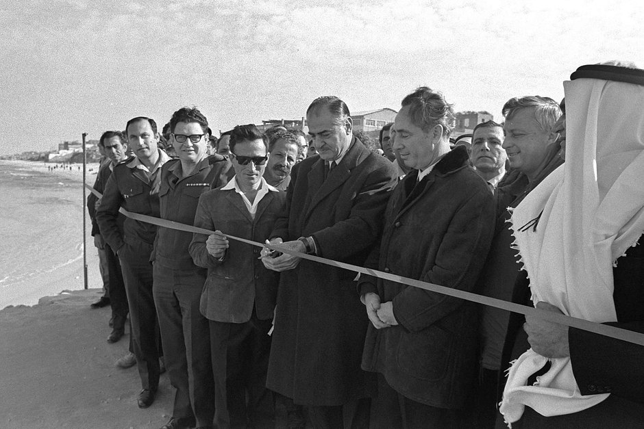 Министр транспорта Израиля Шимон Перес (третий справа) и генерал южного командования Ариэль Шарон наблюдают, как мэр Рушад А'Шава перерезает ленточку на открытии нового пирса в порту города Газы, 13 января 1972 года