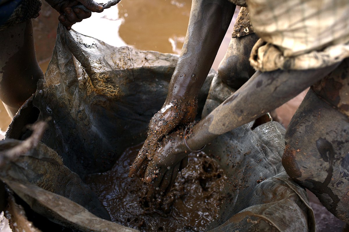 Молодые люди чистят мешки с кобальтом, вывезенные из кобальтовой шахты Руаши, примерно в 20 километрах от Лубумбаши, ДР Конго, 13 декабря 2005 года