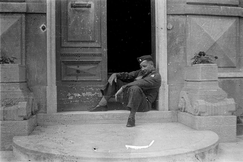 Американский военный позирует, сидя у подъезда. Генуя, Италия. 1945 год