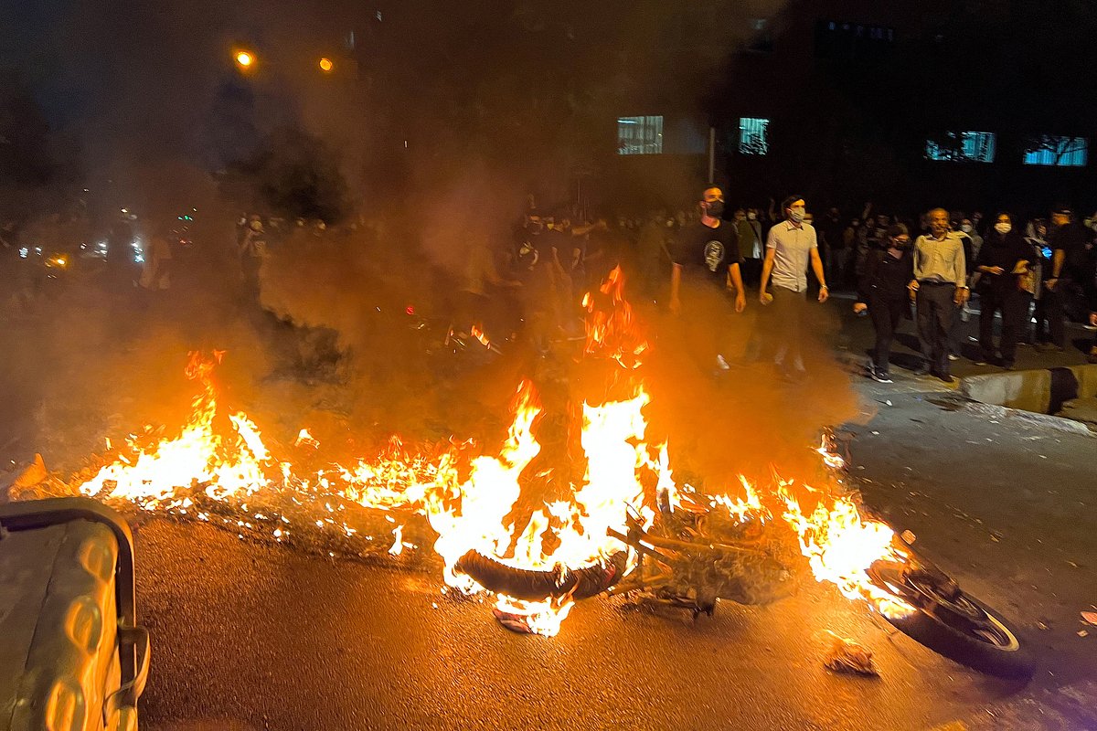 Полицейский мотоцикл горит во время акции протеста в Тегеране, Иран, 19 сентября 2022 года