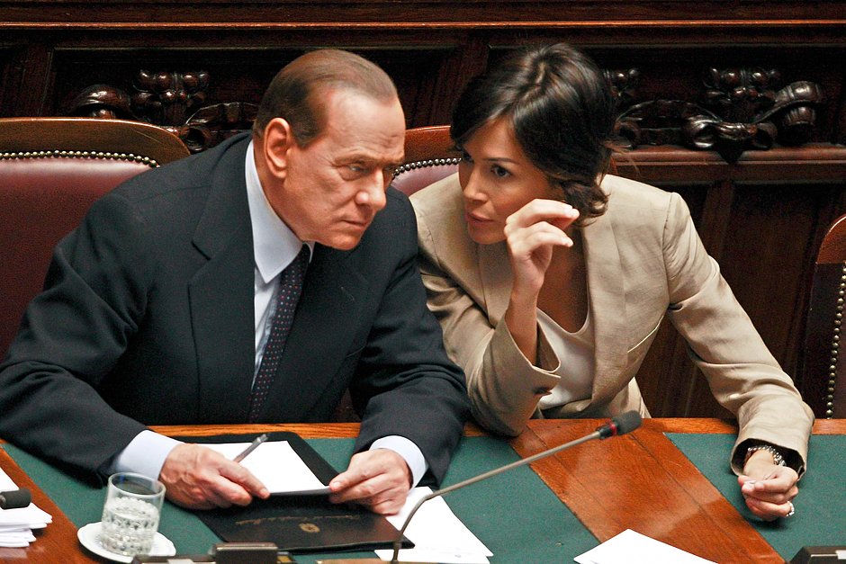 Премьер-министр Италии Сильвио Берлускони беседует с министром по вопросам равных возможностей Марой Карфанья в нижней палате депутатов в Риме, 22 июня 2011 года