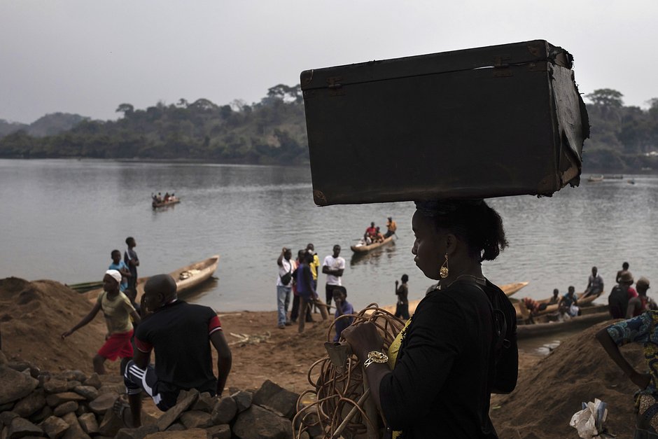 Люди в поисках убежища переправляются через реку Мбому в ЦАР из ДР Конго, 14 февраля 2021 года