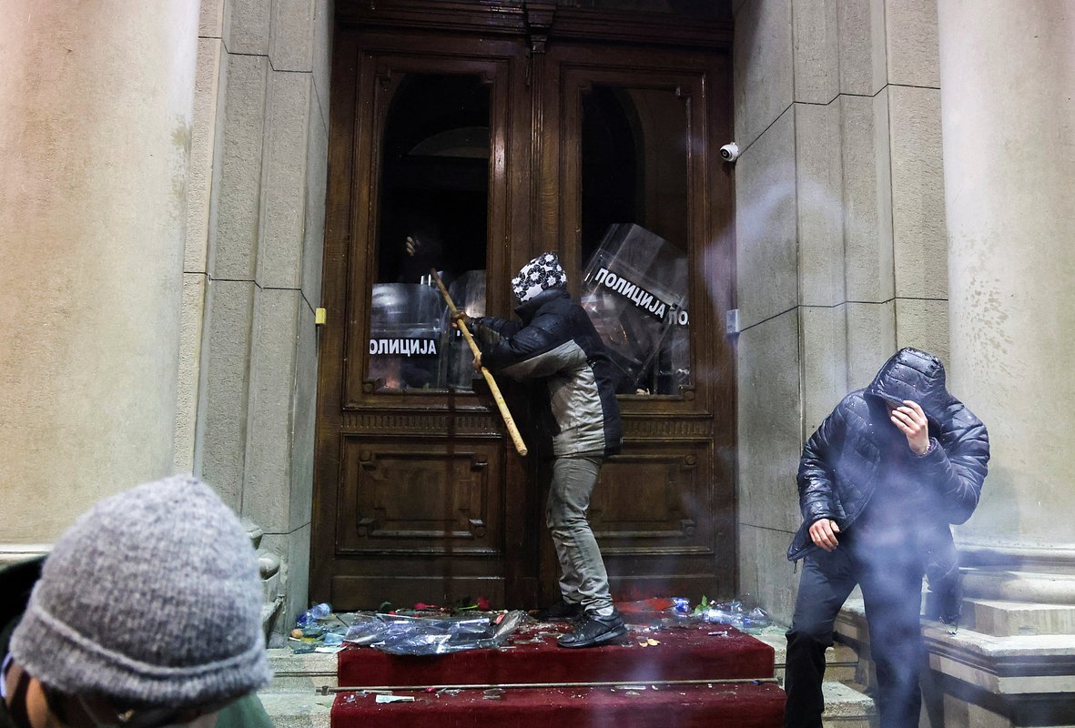 Полицейские прикрывают дверь в здание мэрии во время акции протеста сторонников оппозиции «Сербия против насилия», Белград, Сербия, 24 декабря 2023 года