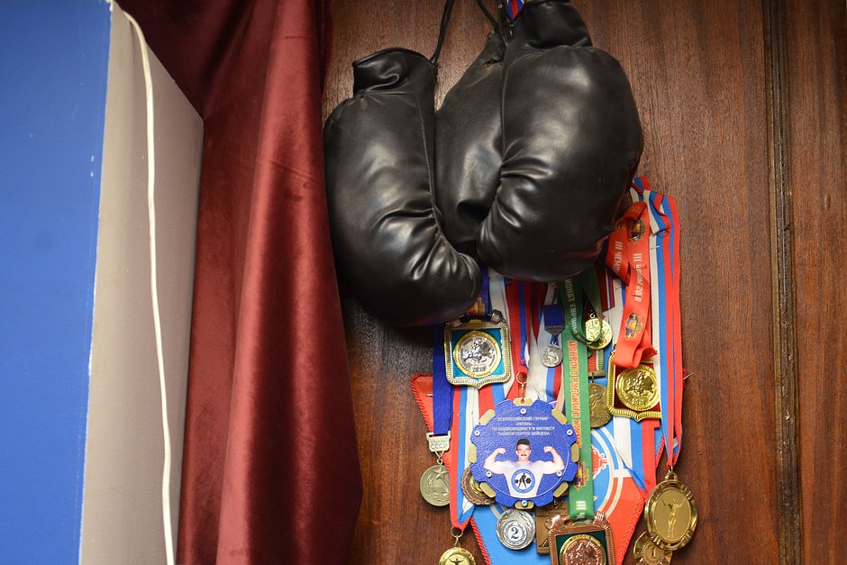 Медали и перчатки на стене в качалке «Титан-Любер»