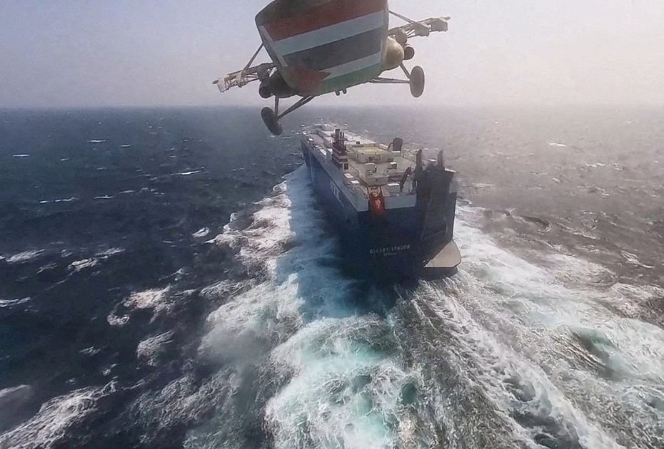 Военный вертолет хуситов пролетает над грузовым кораблем Galaxy Leader в Красном море.