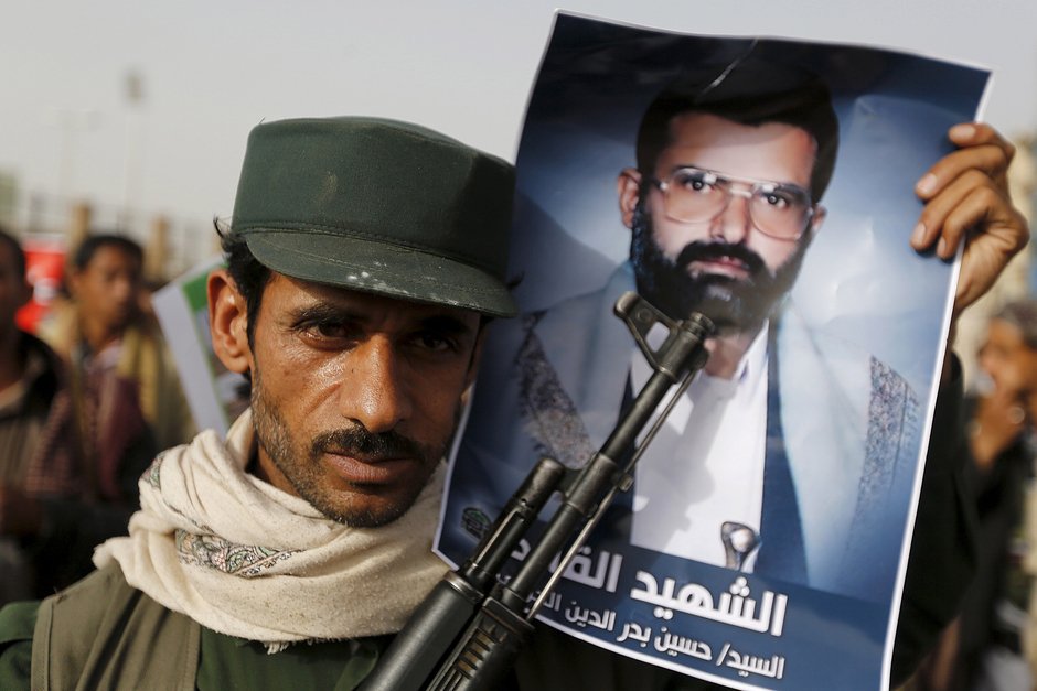 Боевик-хусит держит плакат с изображением основателя движения хуситов Хусейна Бадруддина аль-Хуси во время демонстрации против авиаударов под руководством Саудовской Аравии в столице Йемена Сане, 18 мая 2015 года