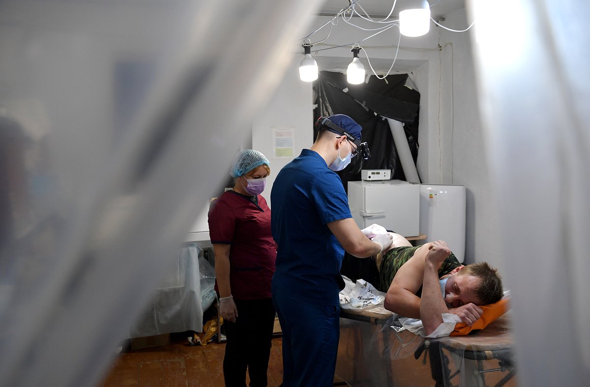 Сотрудники отдельного медицинского отряда выполняют перевязку военного, раненного в Запорожской области