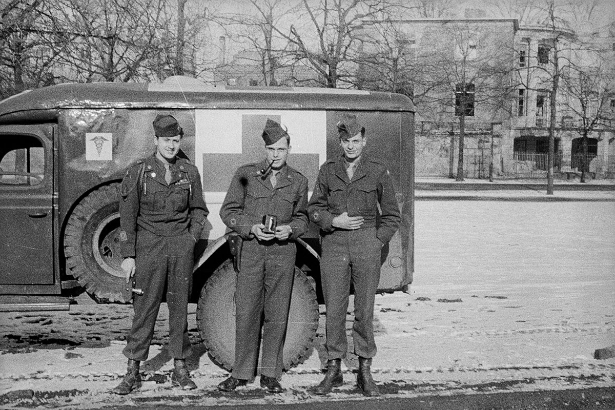 Американские военные с фотокамерами у медицинского армейского автомобиля. Кельн, Германия