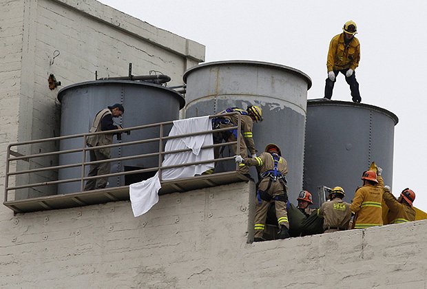 Сотрудники экстренных служб вытаскивают тело Элизы Лэм, найденное в резервуаре с водой на крыше отеля «Сесил» в Лос-Анджелесе, Калифорния