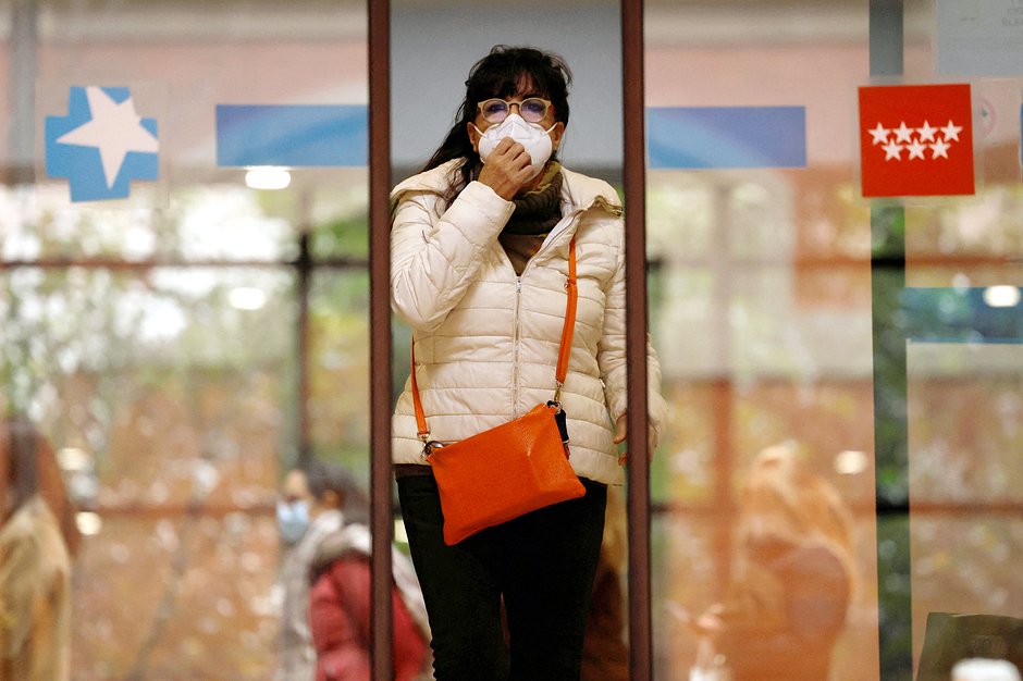 A woman wearing a protective face mask leaves a health center in Madrid, Spain
