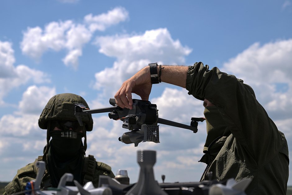Инструктор обучает военнослужащих использованию разведывательного дрона с подвесом для сброса боеприпаса на полигоне в зоне СВО