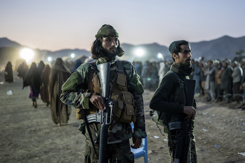 Бойцы «Талибана» стоят на страже, пока афганские беженцы выстраиваются в очередь для регистрации в лагере Торкхам, Афганистан, 4 ноября 2023 года
