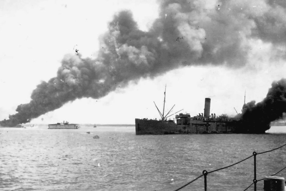 Горящее и тонущее в результате японского авианалета австралийское транспортное судно Zealandia в порту Дарвин. Снимок сделан с австралийского шлюпа Swan, 19 февраля 1942 года
