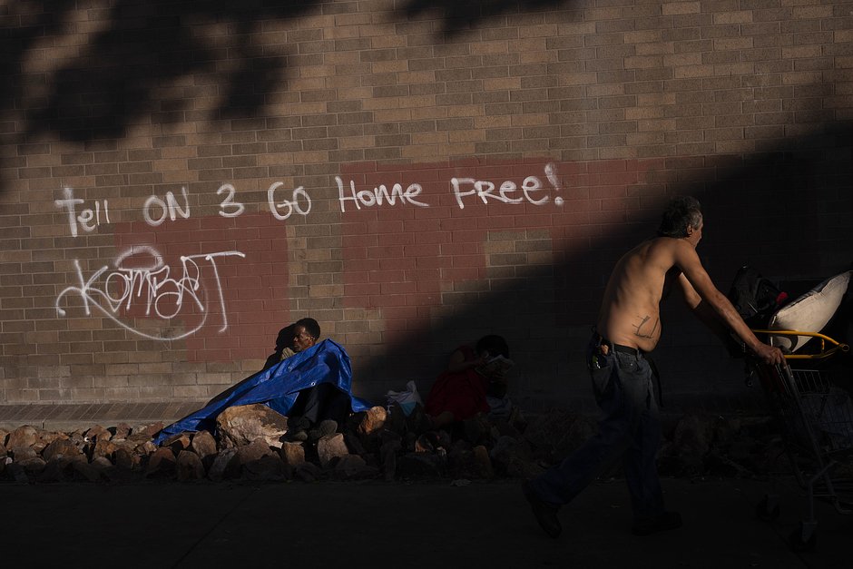 Двое бездомных возле полицейского участка в районе Скид-Роу в Лос-Анджелесе, 14 сентября 2023 года