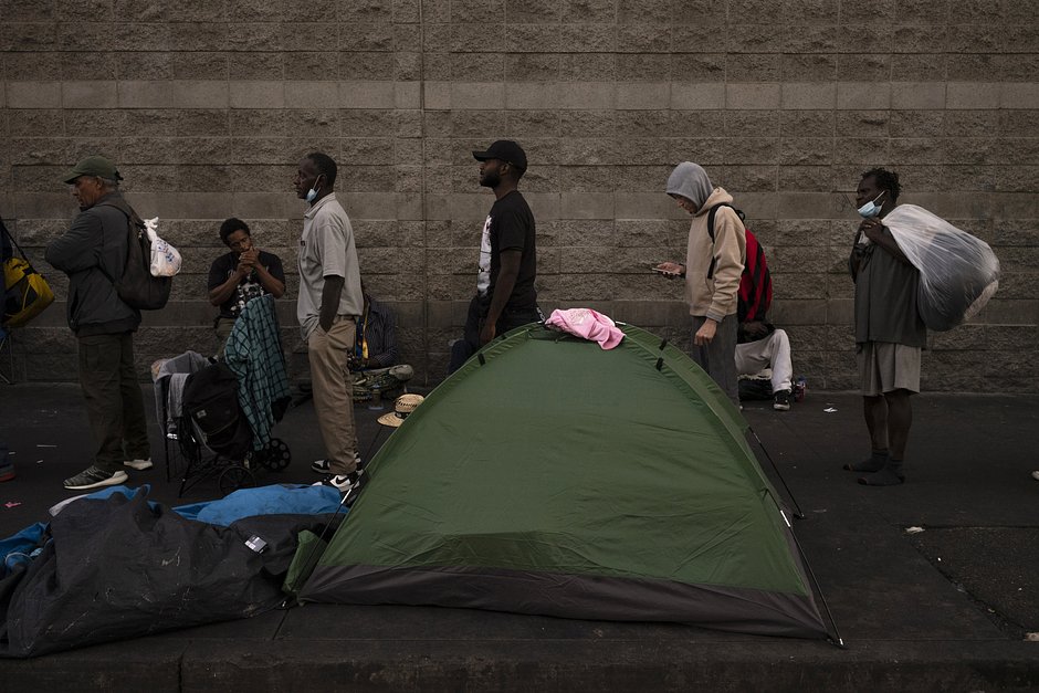 Бездомные стоят в очереди за бесплатным ужином возле Midnight Mission в районе Скид-Роу в Лос-Анджелесе, 25 октября 2023 года