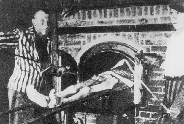 Бывшие узники концлагеря Дахау воспроизводят работу крематория, подталкивая труп к одной из печей