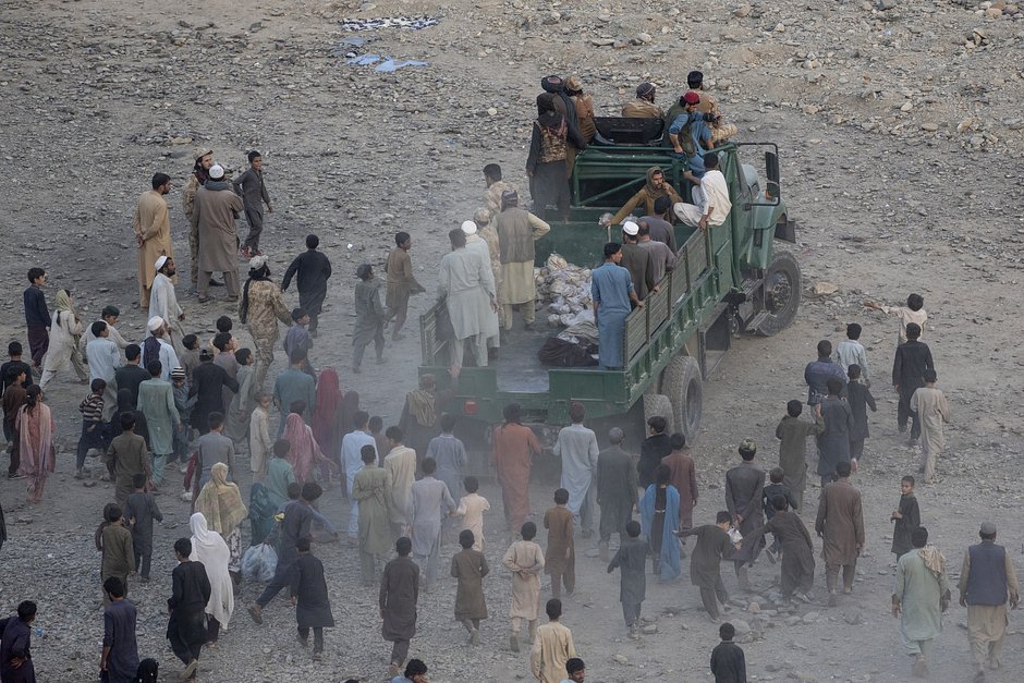 Афганские беженцы следуют за грузовиком, чтобы получить гуманитарную помощь в лагере Торкхам, Афганистан, 3 ноября 2023 года