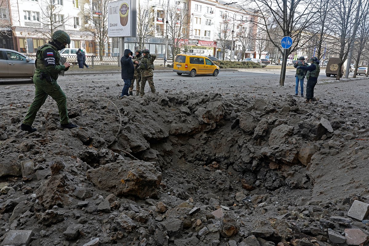 Следователи осматривают воронку возле здания библиотеки в Донецке