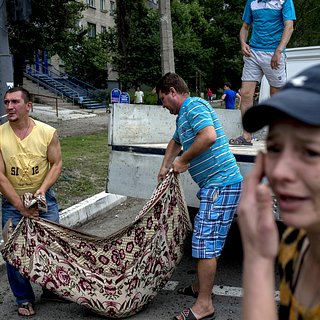 Жители Луганска складывают тела погибших в результате артиллерийского обстрела города.