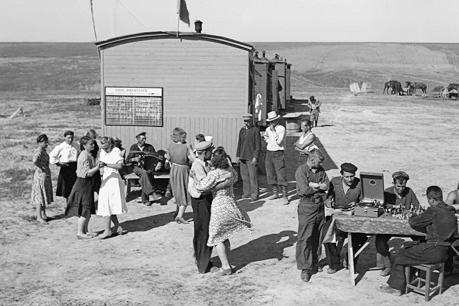 Молодые целинники танцуют в свободное от работы время около вагончиков, в которых они живут в казахской степи. Май 1963 года