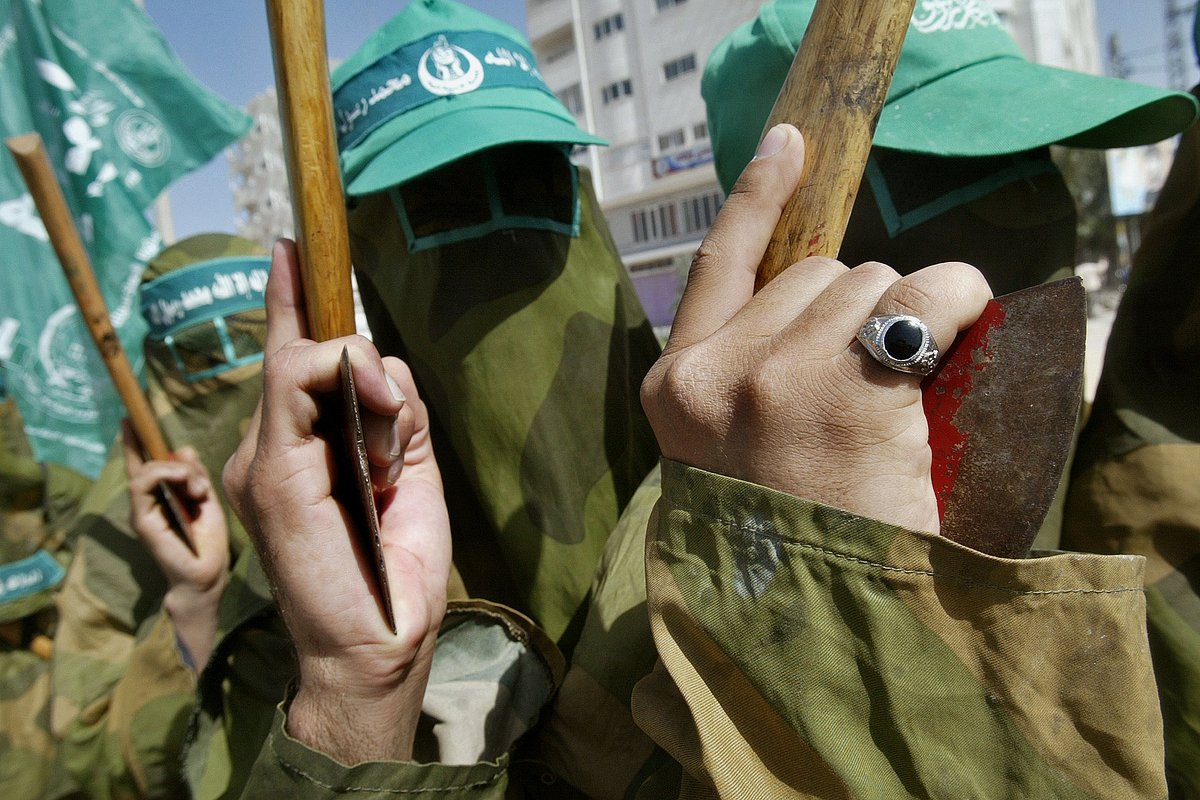 Палестинские боевики ХАМАС с топорами на митинге в лагере беженцев Носират в секторе Газа, 1 апреля 2005 года