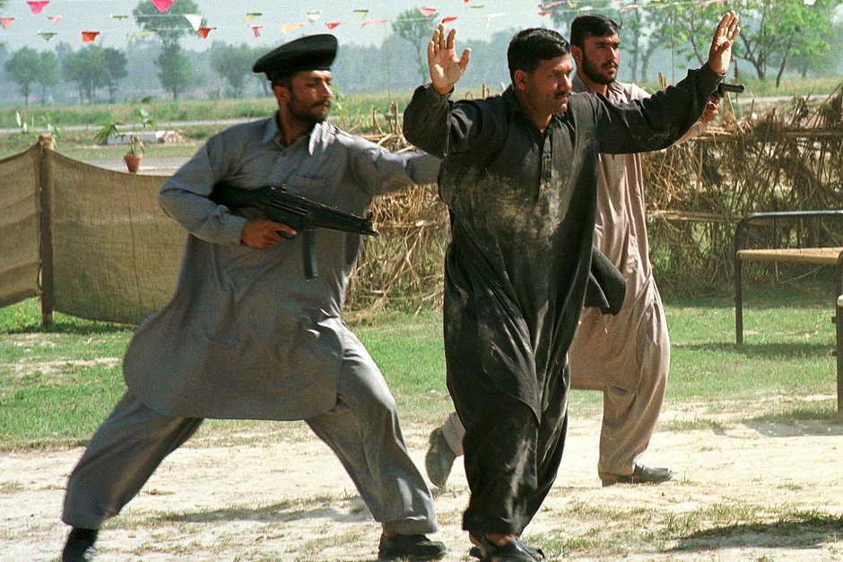 Член антитеррористического отряда специальной полиции Пакистана арестовывает «террориста» во время демонстрации навыков правоохранителей, 13 апреля 1998 года