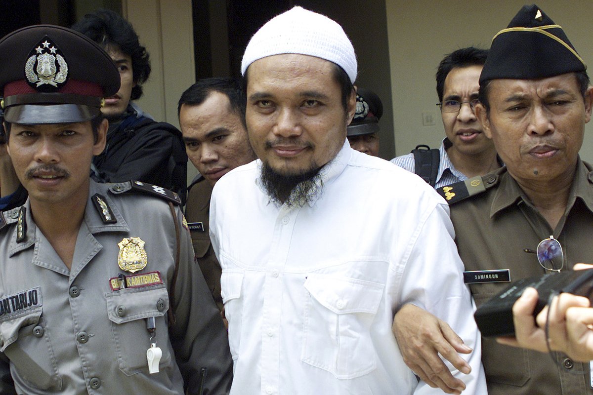 Воинствующего священнослужителя Абу Русдана (в центре) сопровождают сотрудники службы безопасности после судебного заседания в окружном суде Джакарты, Индонезия, 3 ноября 2003 года