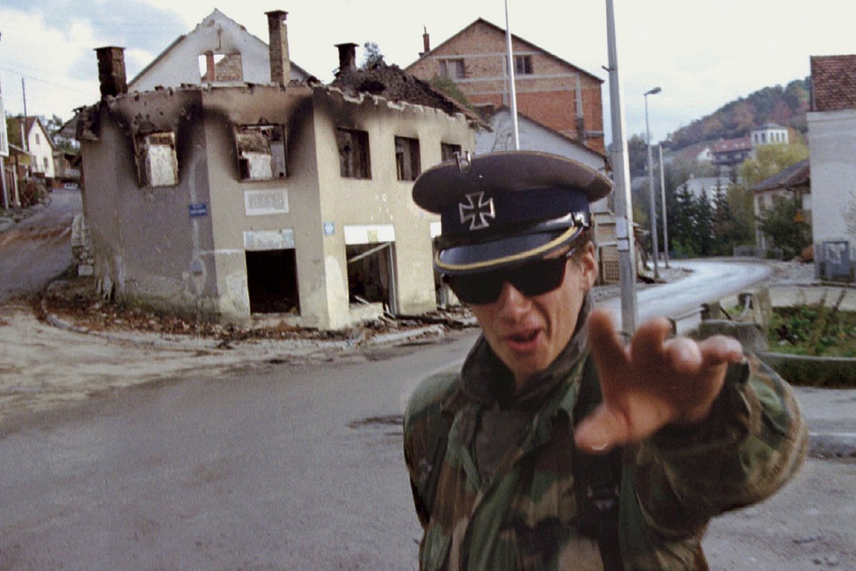 Солдат боснийско-хорватского ополчения в винтажной немецкой кепке времен Второй мировой войны отмахивается от фотографа в городе Прозор, 28 октября 1992 года