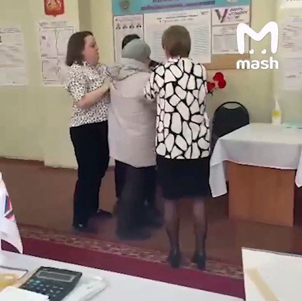 Пенсионерка (в центре), задержанная за облитые зеленкой бюллетени на одном из избирательных участков в России 